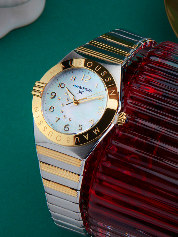 Montre femme Mauboussin 1827 en acier, nacre et diamants portée au poignet d'une mannequin femme